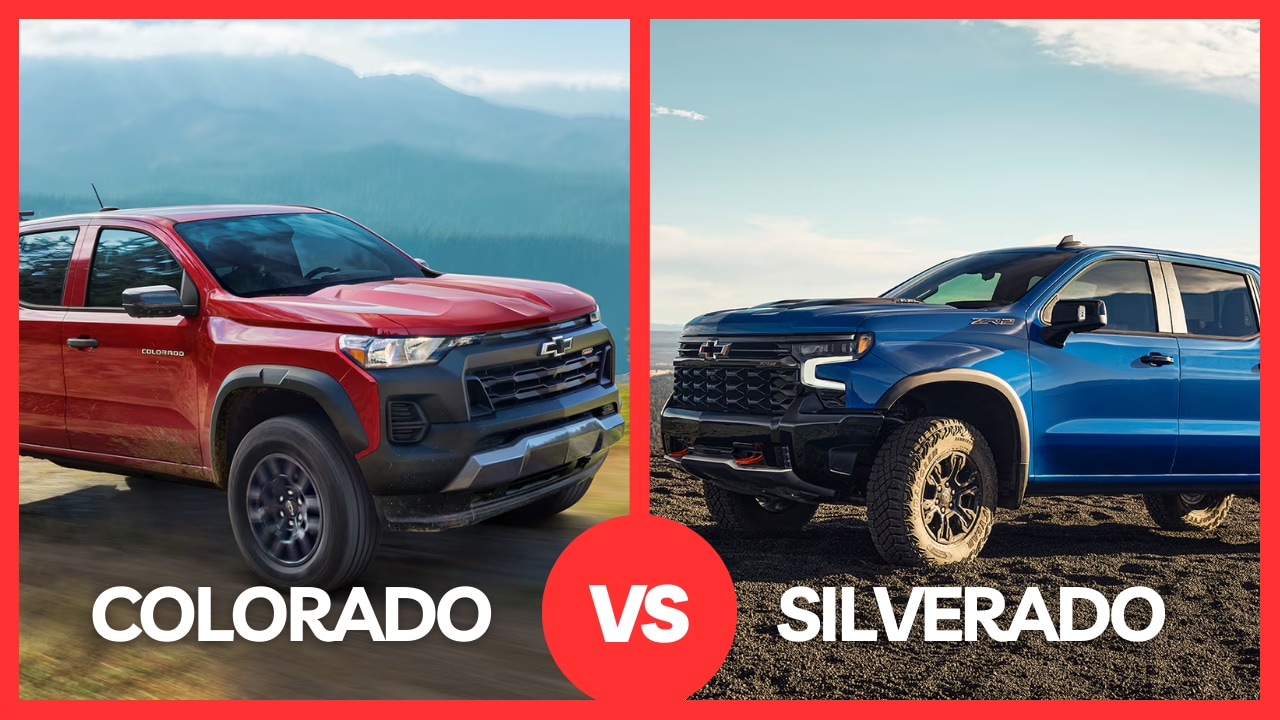 A blue and Red Chevrolet Colorado pickup truck driving through shallow water, splashing around it. A cliff is in the background.