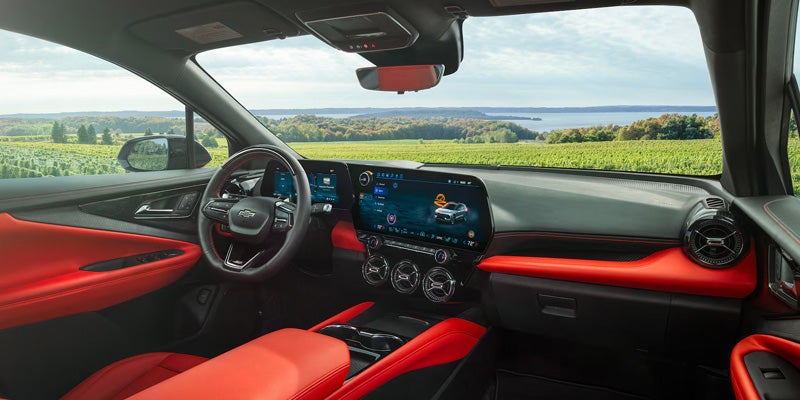 Modern Chevrolet vehicle interior featuring a digital dashboard, infotainment screen, and red-accented seats.